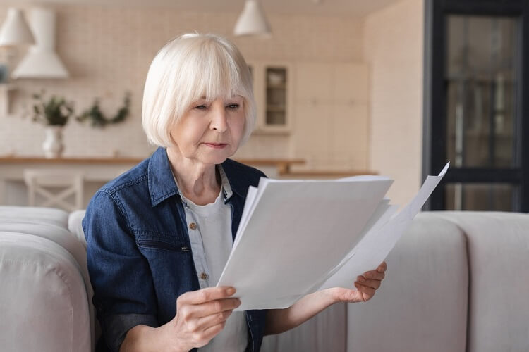 Frau liest den Rentenbescheid