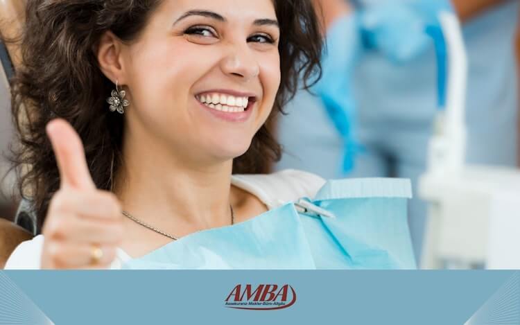 Eine glückliche Frau lächelt, während sie beim Zahnarzt ist, was die Bedeutung einer guten Zahnzusatzversicherung unterstreicht.